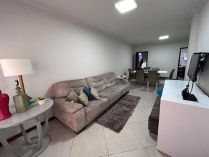 Apto 101 Edifício Manoel Teixeira في أرويو دو سيلفا: غرفة معيشة بها أريكة وطاولة