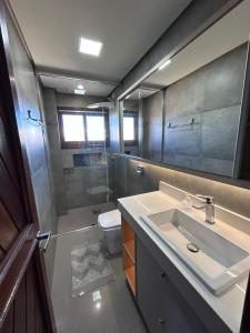 Apto 101 Edifício Manoel Teixeira في أرويو دو سيلفا: حمام مع حوض ومرحاض ومرآة