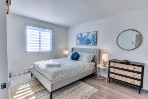 a bedroom with a bed and a mirror and a dresser at Comfy 2BR Pierrefonds Apt with included parking in Montréal +28 photos