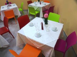 una sala da pranzo con due tavoli e sedie colorate di Affittacamere Rooms Di Matteo a San Paolo di Iesi