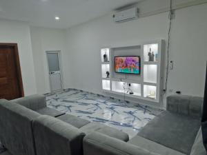 a living room with a couch and a tv at Família Augusto in Luanda