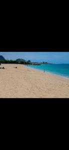 a picture of a beach with people laying on the sand at Família Augusto in Luanda
