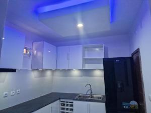a kitchen with white cabinets and a sink at Família Augusto in Luanda