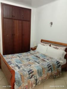 a bedroom with a bed and a wooden cabinet at studio avec piscine et wifi à cabonegro in Cabo Negro +24 photos