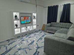 a living room with a couch and a marble floor at Família Augusto in Luanda +10 photos