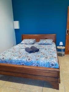a bedroom with a bed with a blue wall at Villa de la convenance in Sainte-Marie