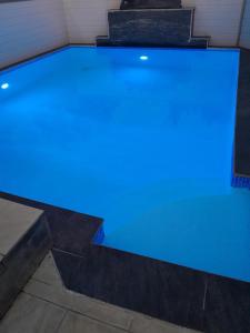 a swimming pool with blue lighting in a house at Villa de la convenance in Sainte-Marie