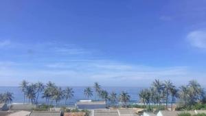 a view of the ocean with palm trees and buildings at Khách Sạn - Homestay QUANG VINH Đảo Lý Sơn in Ly Son