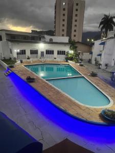 a large swimming pool with blue lights on it at Condomínio Martim de Sá in Caraguatatuba