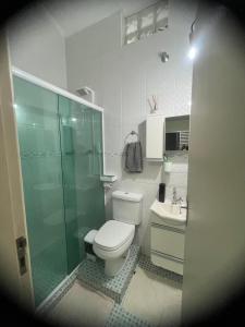 a bathroom with a toilet and a shower and a sink at Condomínio Martim de Sá in Caraguatatuba