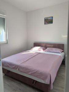 a bedroom with a large bed with pink sheets at Hubby Resort in Mostar