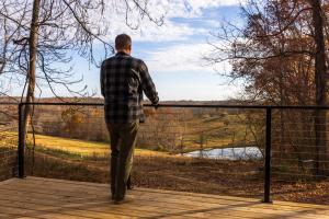 a man standing on a deck looking over a fence at The Ffern in Logan