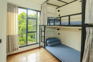 ein Schlafzimmer mit Etagenbetten und einem großen Fenster in der Unterkunft Dengba International Youth Hostel - Shenzhen Futian Convention and Exhibition Center Branch in Shenzhen + 9 Fotos
