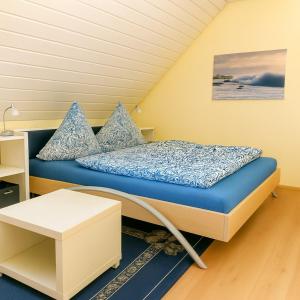a bed with blue sheets and pillows in a room at Fewo Birnau in Unteruhldingen
