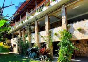 a building with potted plants on the side of it at Pousada Canto das Corujas in São Roque