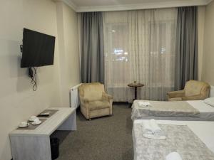 ein Hotelzimmer mit zwei Betten und einem Flachbildfernseher in der Unterkunft Platformatbilisi in Tbilisi City