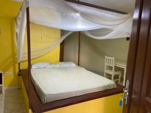 a bed with a canopy in a yellow room at Kernico in Warang