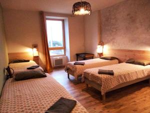 een kamer met drie bedden en een raam bij A la belle étoile - Auberge in Mellionnec