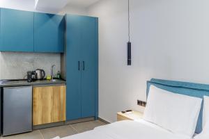 Zimmer mit einem Bett und einer Küche mit blauen Schränken in der Unterkunft Timeless luxury suites & SPA in Thessaloniki + 45 Fotos