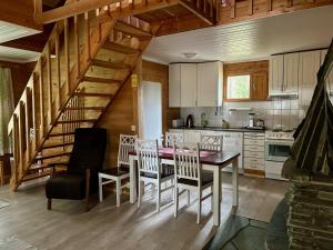a kitchen with a table and chairs and a staircase at Immelmökit in Levi