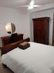 ein Schlafzimmer mit einem Bett mit einer Kommode und einem Spiegel in der Unterkunft Apartment Espiritu Santo in Ronda + 2 Fotos