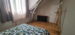 une chambre avec un lit recouvert d'une couette à fleurs et un escalier dans l'établissement Belle appartement, à Monéteau