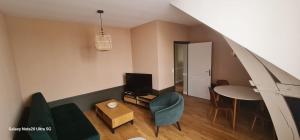 un salon avec un canapé, une table et une télévision dans l'établissement Belle appartement, à Monéteau