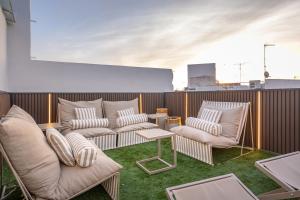 a patio with two chairs and a table on a roof at ODonnell Deluxe Private House by Valcambre in Seville