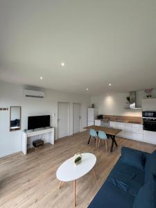 a living room with a blue couch and a table at Maison Bella Vista in La Celle-sous-Gouzon
