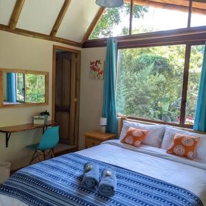 En eller flere senge i et værelse på Casa Mandarina-Lush riverside cloud forest home- walk to town