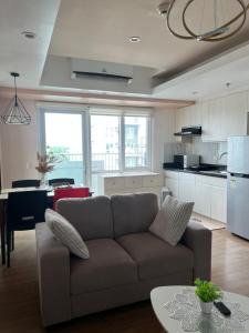 a living room with a couch and a kitchen at Abreeza Tower 1 in Davao City +24 photos