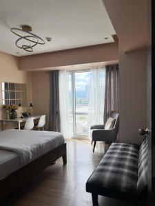 a bedroom with a bed and a desk and a window at Abreeza Tower 1 in Davao City