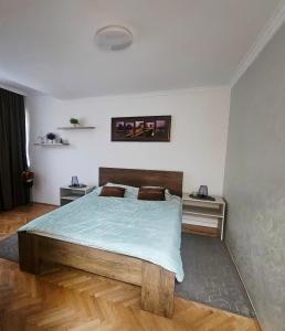 Stan na dan Bijeljina centar في بيه لينا: غرفة نوم بها سرير كبير وطاولتين