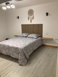 a bedroom with a bed and a wooden floor at La petite maison normande in Luneray