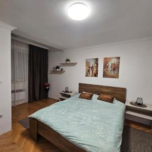 una camera da letto con un letto grande con un piumone blu di Stan na dan Bijeljina centar a Bijeljina