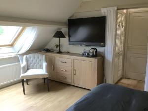 Телевизор и/или развлекательный центр в Le Moulin Bas Chambre d'Hote