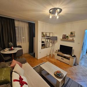 un soggiorno con un divano e un tavolo di Stan na dan Bijeljina centar a Bijeljina