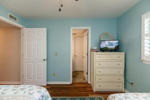 een slaapkamer met een wit dressoir en een blauwe muur bij 214 Bay Creek Villa in Edisto Beach
