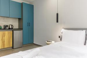 a bedroom with a bed and a kitchen with blue cabinets at Timeless luxury suites & SPA in Thessaloniki +34 photos