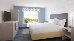 Un dormitorio con una cama grande y una ventana. en Home 2 Suites, en Hernando