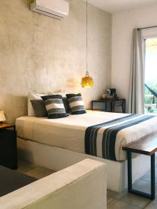 a bedroom with a large bed with pillows at Hotel Aires Bacalar in Bacalar