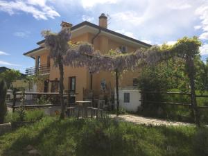 Uma casa com um monte de glicínias. em Agriturismo San Floreano em Buia