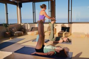a woman standing on her legs in a yoga class at Aman surf paddle yoga in Imsouane