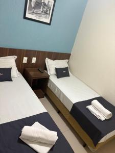 Dos camas en una habitación de hotel con toallas encima. en Downtown Santana Hotel, en Río de Janeiro