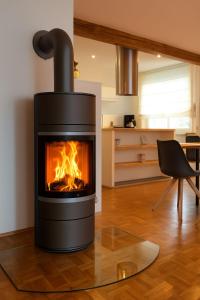 un camino in un soggiorno con sedia di Ferienhaus Sauerzapf mit Saunabereich 16 Personen a Braunlage