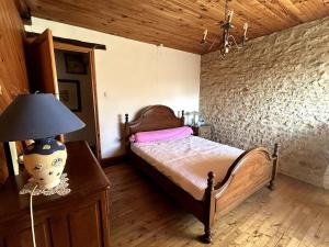 una camera da letto con un letto con una lampada e una parete di Maison de campagne a Nanteuil-en-Vallée