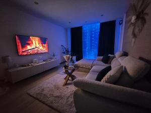 ein Wohnzimmer mit einem Sofa und einem Kamin an der Wand in der Unterkunft Apartmán LUX Lučenec in Lučenec