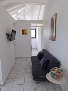 ein Wohnzimmer mit einer schwarzen Couch und einem Tisch in der Unterkunft Gwada Vakans in Saint-François