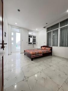 a bedroom with a bed and a large window at 59 Nguyễn Hiền Phòng ban công có một giường in Vung Tau