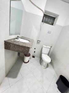 a bathroom with a sink and a toilet at 59 Nguyễn Hiền Phòng ban công có một giường in Vung Tau